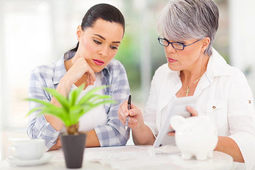 Mid age mother helping daughter with her financial 